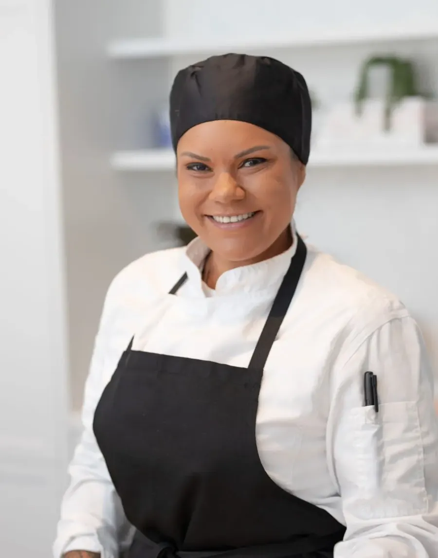 Brita Brundin in her chef whites and black apron, smiling
